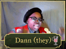 a woman with glasses and a beret says dann ( they)