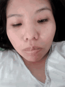 a close up of a woman 's face with a white blanket on