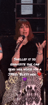 a woman speaking into a microphone with a warning sign behind her