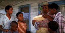 a group of people standing on a porch looking at a piece of paper