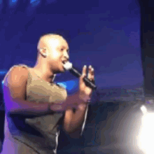 a man singing into a microphone on a stage