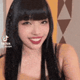 a young woman with long black hair and braids is smiling .