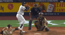 a baseball game is being played in front of a yankees advertisement