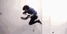 a man in a blue shirt is jumping in the air