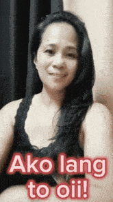 a woman in a black tank top with the words ako lang to oil