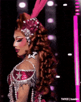 a drag queen is wearing a red and silver outfit with a star on the chest