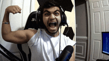 a man wearing headphones with the letter s on the back flexes his arm
