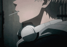 a person with headphones around their neck smoking a cigarette