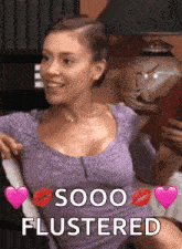 a woman in a purple shirt is sitting in a chair with hearts and the words soooo flustered .