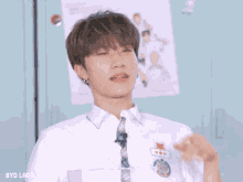 a young man wearing a white shirt and tie has a name tag that says byd land