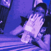 a person is holding a bottle of water in their hand