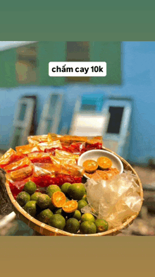 a person is holding a basket of fruit with a sticker that says chăm cay 10k