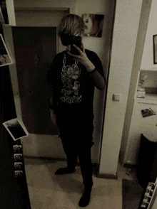 a person taking a selfie in front of a mirror with a t-shirt that says ' swedish ' on it