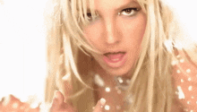 a close up of a blonde woman 's face with her tongue out