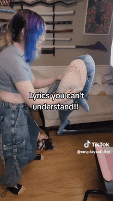 a woman is holding a stuffed shark with lyrics you can 't understand