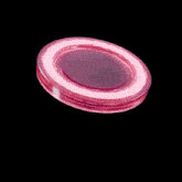 a pink coin with liquid dripping from it on a black background