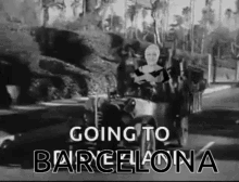 a black and white photo of a woman driving a car with the words `` going to barcelona '' on the bottom .