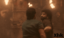 two men are fighting in a dark room with xhk written in the corner
