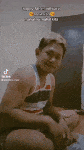 a man in a tank top sits with his legs crossed and says happy 8th monthary asawa ko mahal na mahal kita