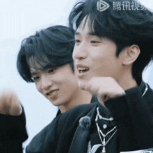 two young men are standing next to each other and one of them is wearing a necklace that says ' a ' on it