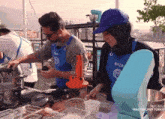 a man and a woman wearing aprons that say seyza are preparing food