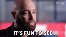 a man with a beard is saying `` it 's fun to see '' while looking at something .