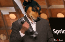 a man in a suit has a dog 's head on his head in front of a sign that says ' the big lead '