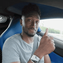 a man in a car giving a thumbs up sign