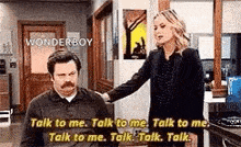 a man and a woman are talking to each other .