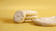 a person is sprinkling powdered sugar on a pile of cookies