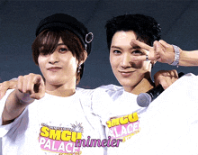 two men wearing smgu palace t-shirts pointing at the camera