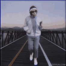 a man is running on a bridge with gifrun.com written on the bottom right