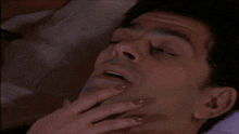 a close up of a man 's face with a woman 's hands on it