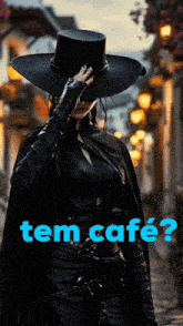 a woman wearing a black hat and cape is standing in front of a sign that says tem cafe on it