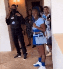 a group of people are standing around a woman in a cheerleader costume .