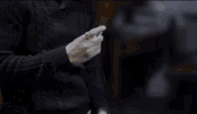 a man in a black sweater holds a lighter in his hand