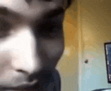 a close up of a person 's face in front of a wall