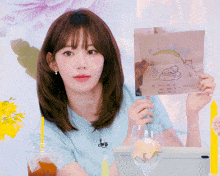 a woman holds up a drawing of a cat and a leaf with the words " i love you " on it