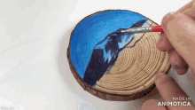 a person is painting a picture on a piece of wood with the words made in animatica below it