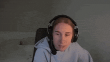 a woman wearing headphones and a microphone is sitting in front of a computer .