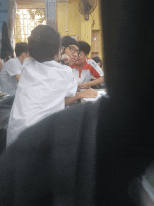 a group of people sitting around a table with a sign behind them that says " em "