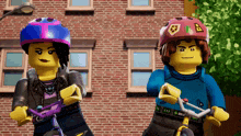 two lego figures wearing helmets are riding bicycles