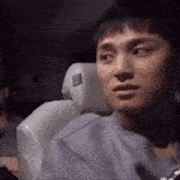 a man is sitting in the back seat of a car looking at the camera .