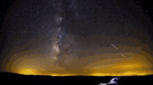 the milky way is visible in the night sky above the mountains