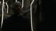 a man in a futuristic suit looks at another man