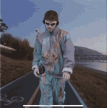 a man wearing sunglasses and headphones is walking down a path
