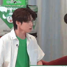 a man wearing a green shirt and a white shirt is standing in front of a bag that says nb man