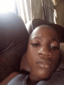 a young boy is laying on a couch and looking at the camera