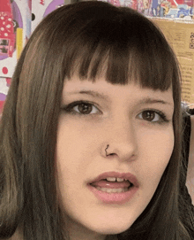 a close up of a woman 's face with a nose piercing