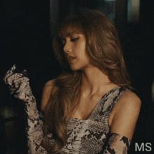 a woman wearing a snake print dress and gloves with the letters ms on the bottom